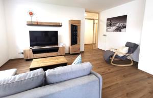 a living room with a couch and a flat screen tv at Ferienwohnungen Alpenliebe & Auszeit in Sonthofen