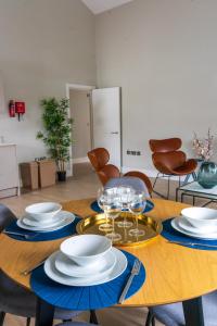 einen Holztisch mit Tellern und Weingläsern darauf in der Unterkunft Beautiful New 2 Bed Flat - 5 August House in London