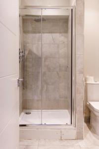 a shower with a glass door in a bathroom at Beautiful New 2 Bed Flat - 5 August House in London