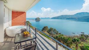 a balcony with a bath tub and a view of the water at Arasol Pension in Geoje