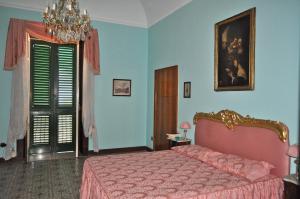 a bedroom with a pink bed and blue walls at Villa Elizabeth in Milazzo