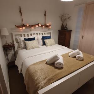een slaapkamer met een groot wit bed en handdoeken bij Helen of Troy House in Loutra Oraias Elenis 
