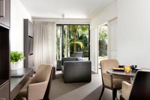 a living room with a table and a couch at Pier 21 Apartment Hotel Fremantle in Fremantle