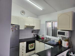 a kitchen with white cabinets and a stainless steel refrigerator at Jasmin Gardens in Paphos City