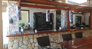 un restaurante con un bar con una pared de piedra en birdwatchers beachfront hotel panglao en Panglao City