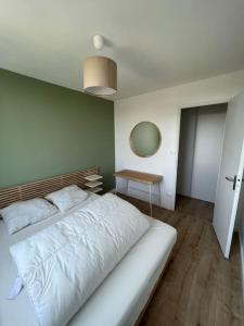 卡魯雷埃奎耶的住宿－Le Calme - Design - Vue panoramique sur la Saône，卧室配有一张白色的大床和一张桌子