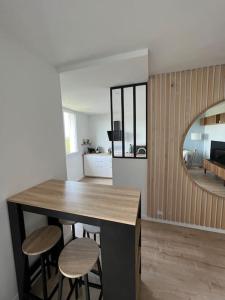 uma cozinha com um balcão e bancos num quarto em Le Calme - Design - Vue panoramique sur la Saône em Caluire-et-Cuire