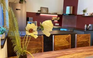 une cuisine avec une table et quelques fleurs jaunes dans l'établissement TS Apartments, à Traunstein