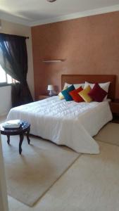 a bedroom with a white bed with colorful pillows at Villa Marrakech in Marrakesh