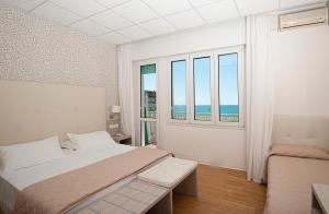 a bedroom with a bed and a large window at Hotel Splendid in Caorle