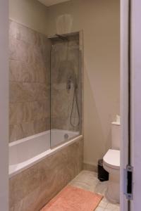 a bathroom with a shower and a toilet at Stunning New 2 Bed Flat - 6 August House in London