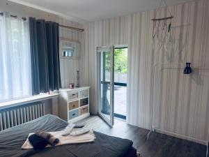 een slaapkamer met een bed en een glazen schuifdeur bij 4 Zimmer 11 Personen Wohnung Garten Terrasse Grill 2 Badezimmer in Wuppertal