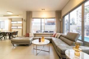 - un salon avec un canapé et une table dans l'établissement O&O Group - Prestigious Beachfront Villa W Private Pool, à Rishon LeẔiyyon