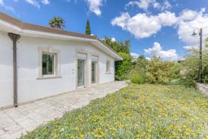 a white house with a yard with yellow flowers at Villa Gianna in Casarano