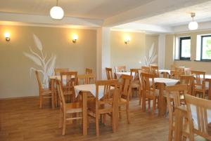 ein Esszimmer mit Holztischen und Stühlen in der Unterkunft Activ Parc in Negreşti