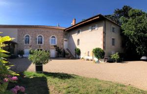 a large brick building with a yard in front of it at Domaine de La Baisse in Saint-Étienne-la-Varenne