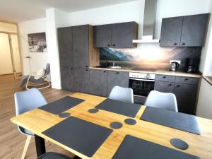 kuchnia z drewnianym stołem i krzesłami w kuchni w obiekcie Ferienwohnungen Alpenliebe & Auszeit w mieście Sonthofen