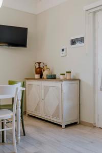 a wooden cabinet in a room with a table and chairs at Il Trullo delle Due Lune in Noci +24 photos
