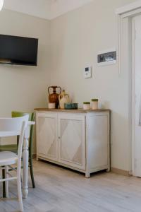 a wooden cabinet in a room with a table and chairs at Il Trullo delle Due Lune in Noci
