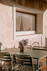 a wooden table with chairs and a vase of purple flowers at Il Trullo delle Due Lune in Noci