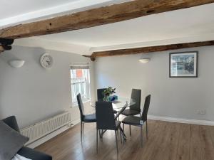 Colchester Town Duplex Apartment في كولشستر: غرفة طعام مع طاولة وكراسي