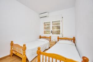 2 camas individuales en una habitación con ventana en Precioso aprtamento en Rocas Doradas frente al mar, en L'Ametlla de Mar