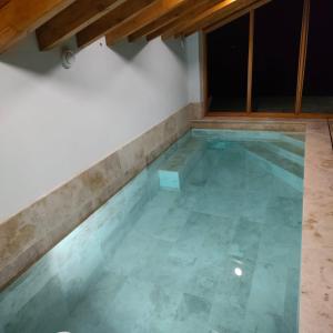 una piscina vacía con suelo de baldosa en Villa Brenagudina - Cabaña Pasiega con piscina climatizada, en San Pedro del Romeral