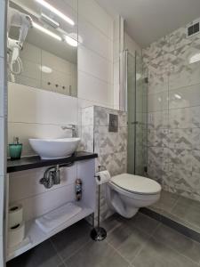 e bagno con servizi igienici, lavandino e doccia. di Villa Bianco a Międzyzdroje