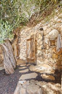 un edificio de piedra con puerta de madera y pared de piedra en Precioso aprtamento en Rocas Doradas frente al mar en L'Ametlla de Mar