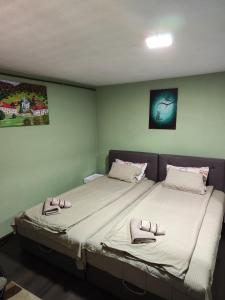a bedroom with two beds with slippers on them at Snezana home in Vranje