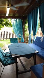 a porch with two beds and a table and chairs at Nefeli Maisonette in Nikiti
