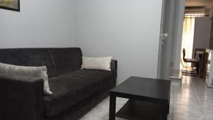 a living room with a black couch and a table at Nefeli Maisonette in Nikiti