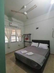 1 dormitorio con 1 cama con 2 toallas en FBS Inn Dungun, en Dungun