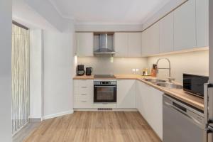 a kitchen with white cabinets and a sink at Apartments Ribnica in Bohinj +21 photos