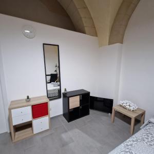 a bedroom with a bed and a table and a mirror at B&B UNICI GRAMMICHELE in Grammichele