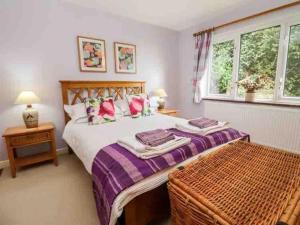 a bedroom with a large bed and a window at Yew Tree Cottage in Colwall