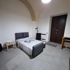 a bedroom with a bed and a table and a door at B&B UNICI GRAMMICHELE in Grammichele