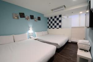 Zimmer mit 2 Betten und einer karierten Wand in der Unterkunft Sleep Taipei in Taipeh