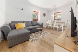 a living room with a gray couch and a table at Apartments Ribnica in Bohinj