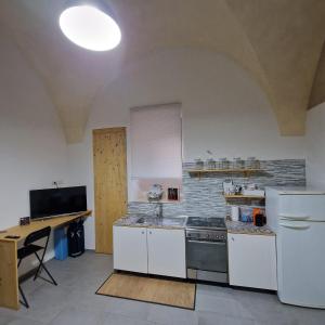 a kitchen with white appliances and a table in it at B&B UNICI GRAMMICHELE in Grammichele