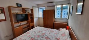 Dormitorio pequeño con cama y TV en Timone, en Roccalumera