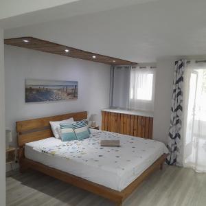 a bedroom with a large bed with a wooden headboard at Holiday Surf Lodge in Tamarin