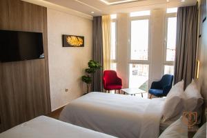 a hotel room with two beds and a flat screen tv at Marchica Hotel in Nador