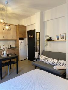 una cucina con divano e tavolo in una camera di Tiny Square a Nafpaktos