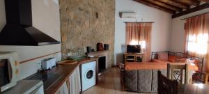a kitchen and a living room with a stove top oven at Casa Rocío in Castril