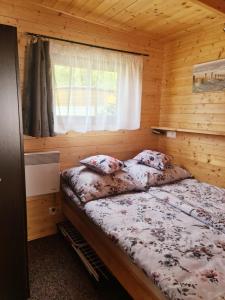 a bedroom with a bed in a wooden cabin at Ośrodek Wypoczynkowy Helkamp in Hel