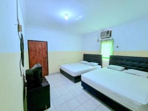 een kamer met 2 bedden en een tv. bij Hotel Taman Sari in Jakarta