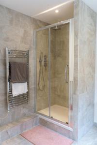 y baño con ducha y puerta de cristal. en Gorgeous New 2 Bed Flat - 2 August House en Londres