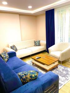 uma sala de estar com um sofá azul e uma mesa em MONEZZA APART em Avcılar