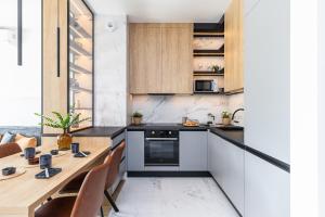 a kitchen with a wooden table and a counter top at SuperApart St. Augusta 71 in Warsaw